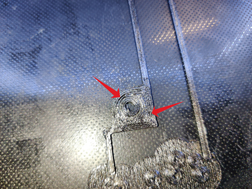 Close-up of a 3D printed part on the build plate currently in progress of being printed. Two arrows point at locations where the perimeter lines aren't attached to each other.